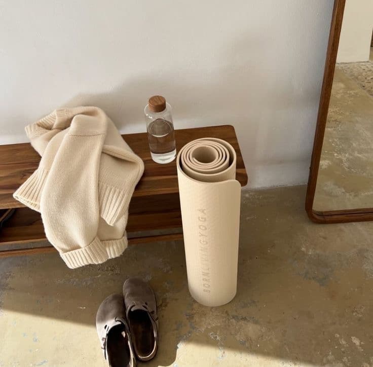 A rolled yoga mat and sweater, ready for fall